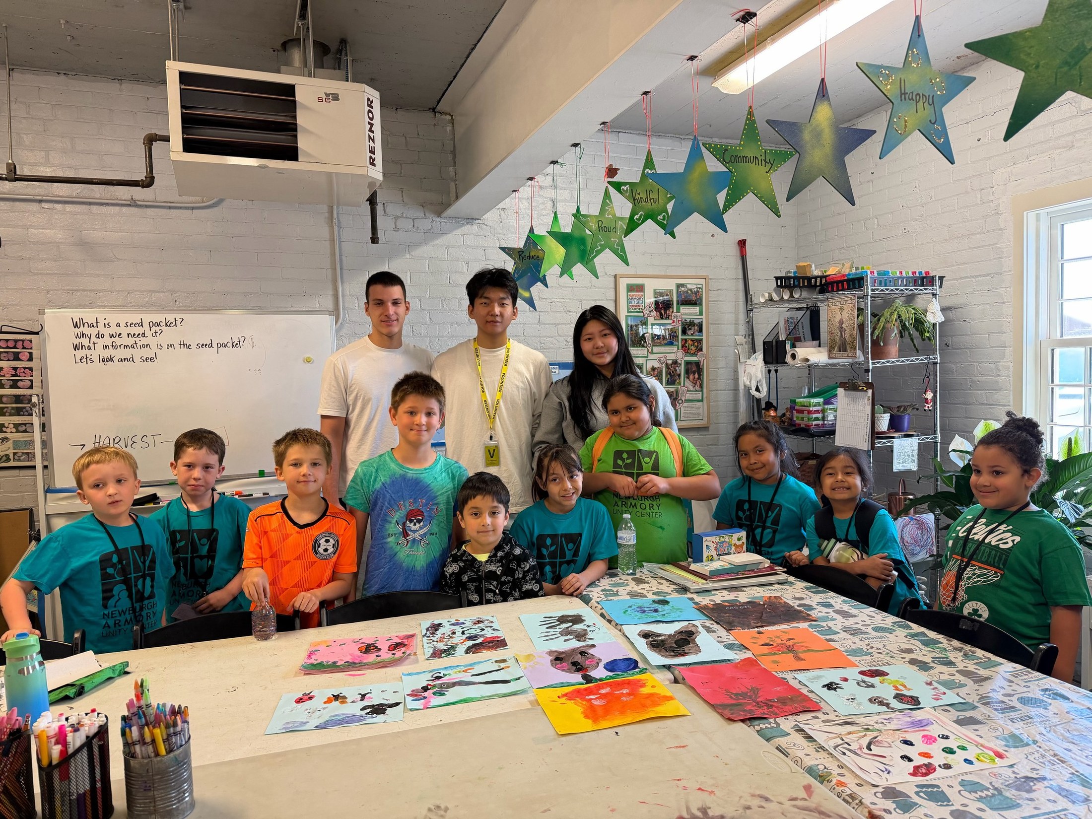 Children and volunteers displaying animal habitat paintings
