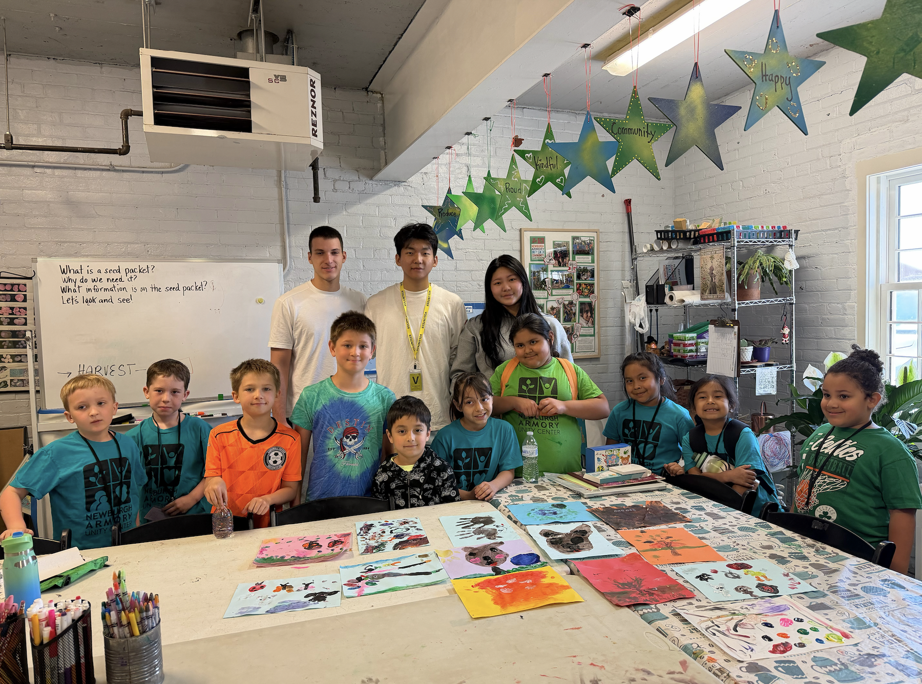 Volunteers and children posing together after an Eco Art Club activity
