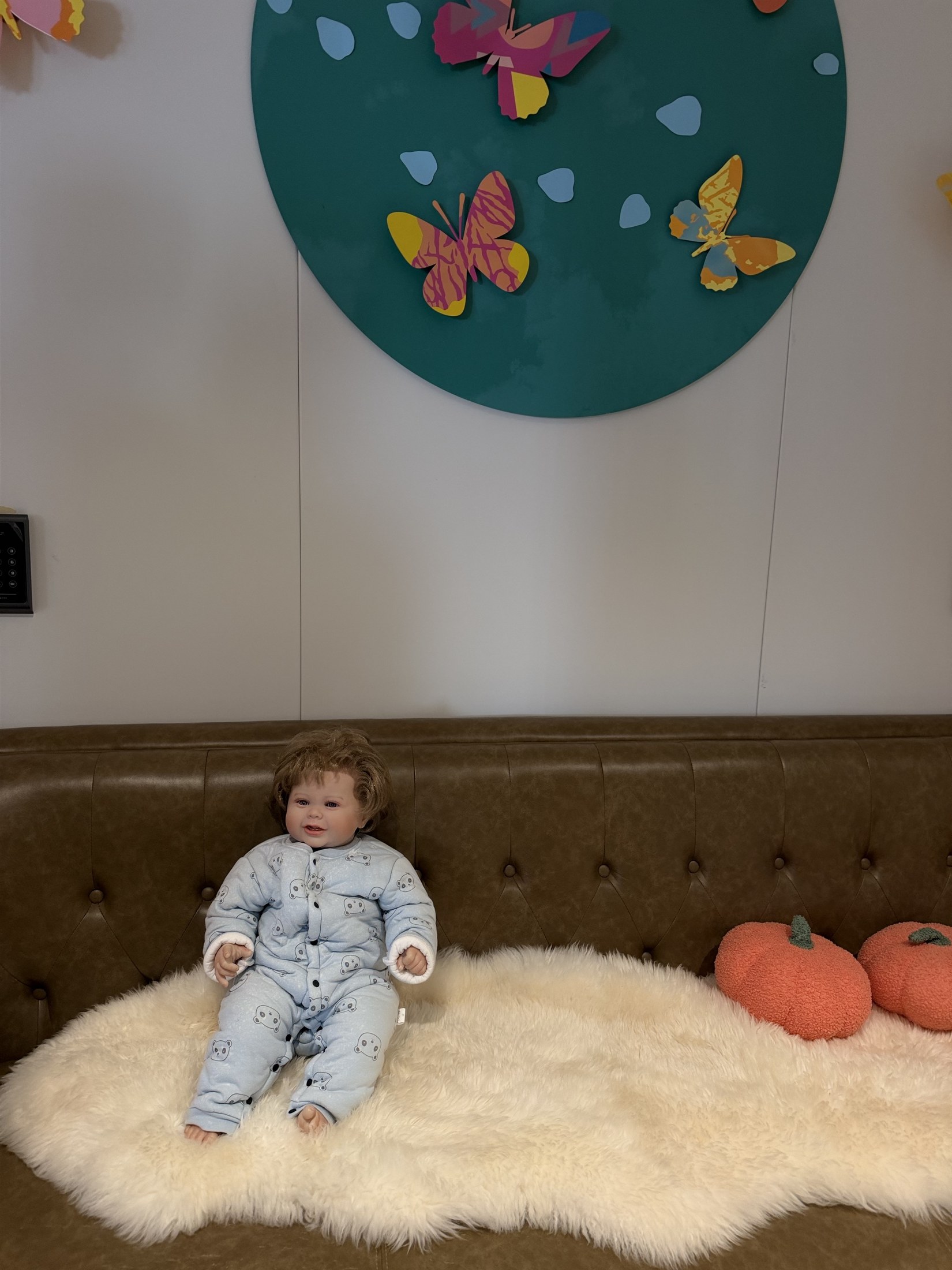 A doll resting on a sofa in the baby corner