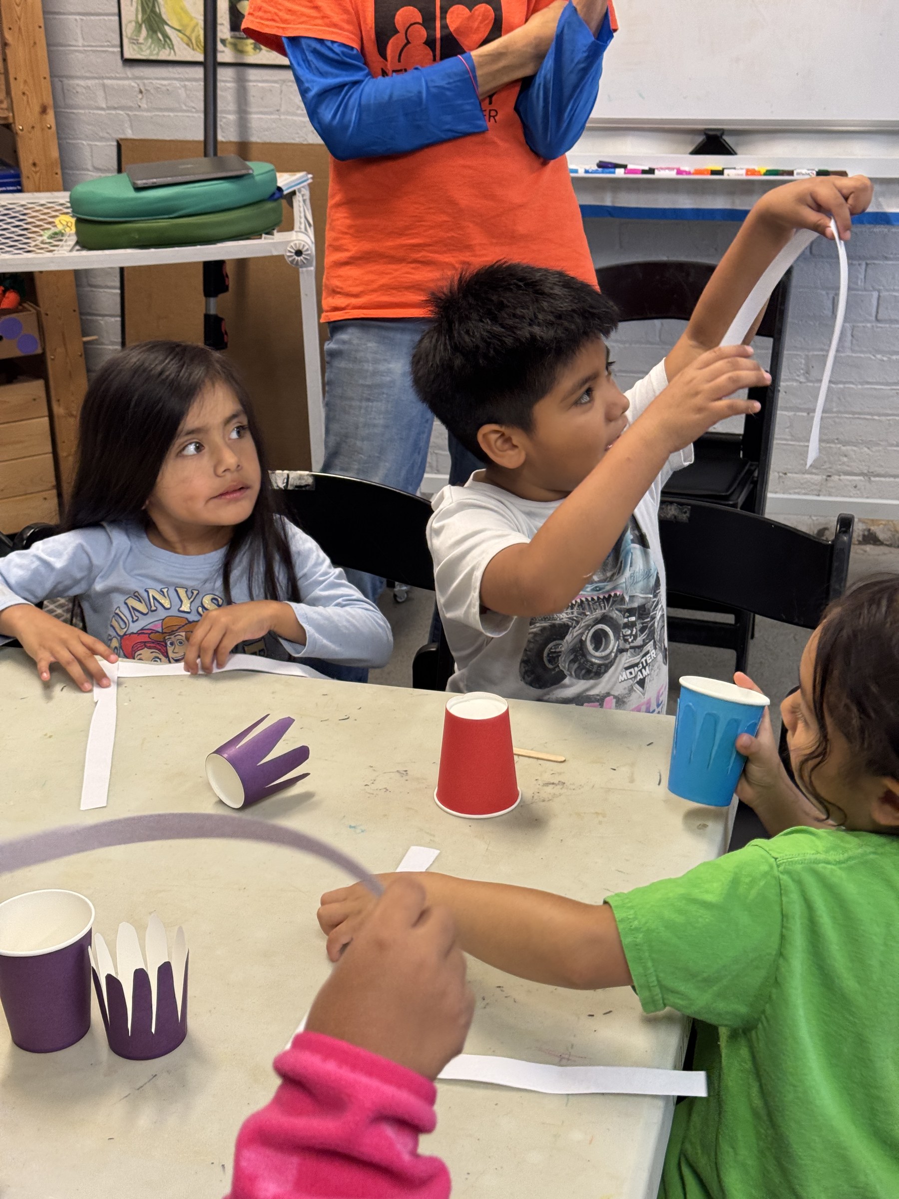 Children measuring paper strips for octopus crafts