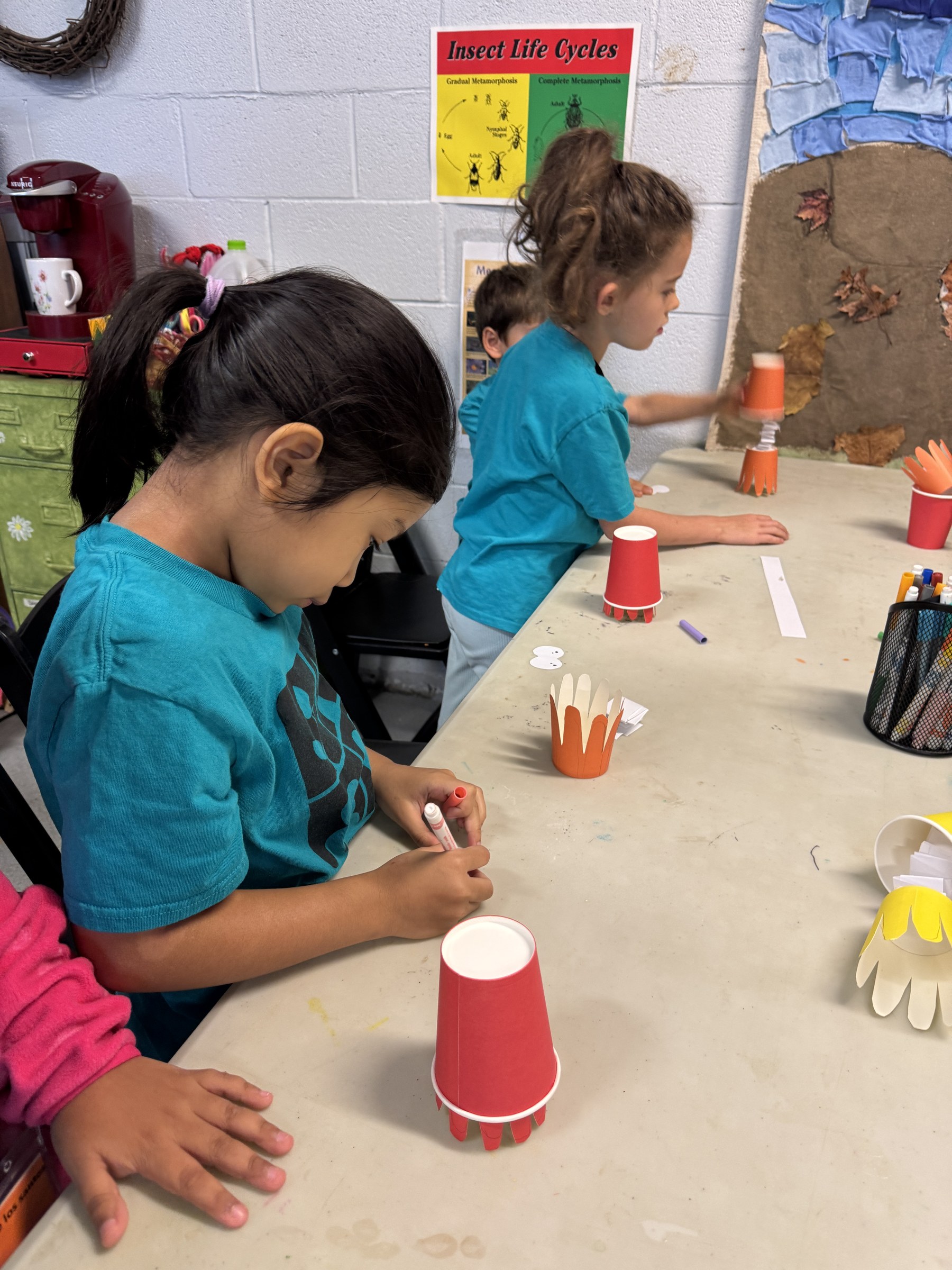 A child decorating a paper-cup octopus