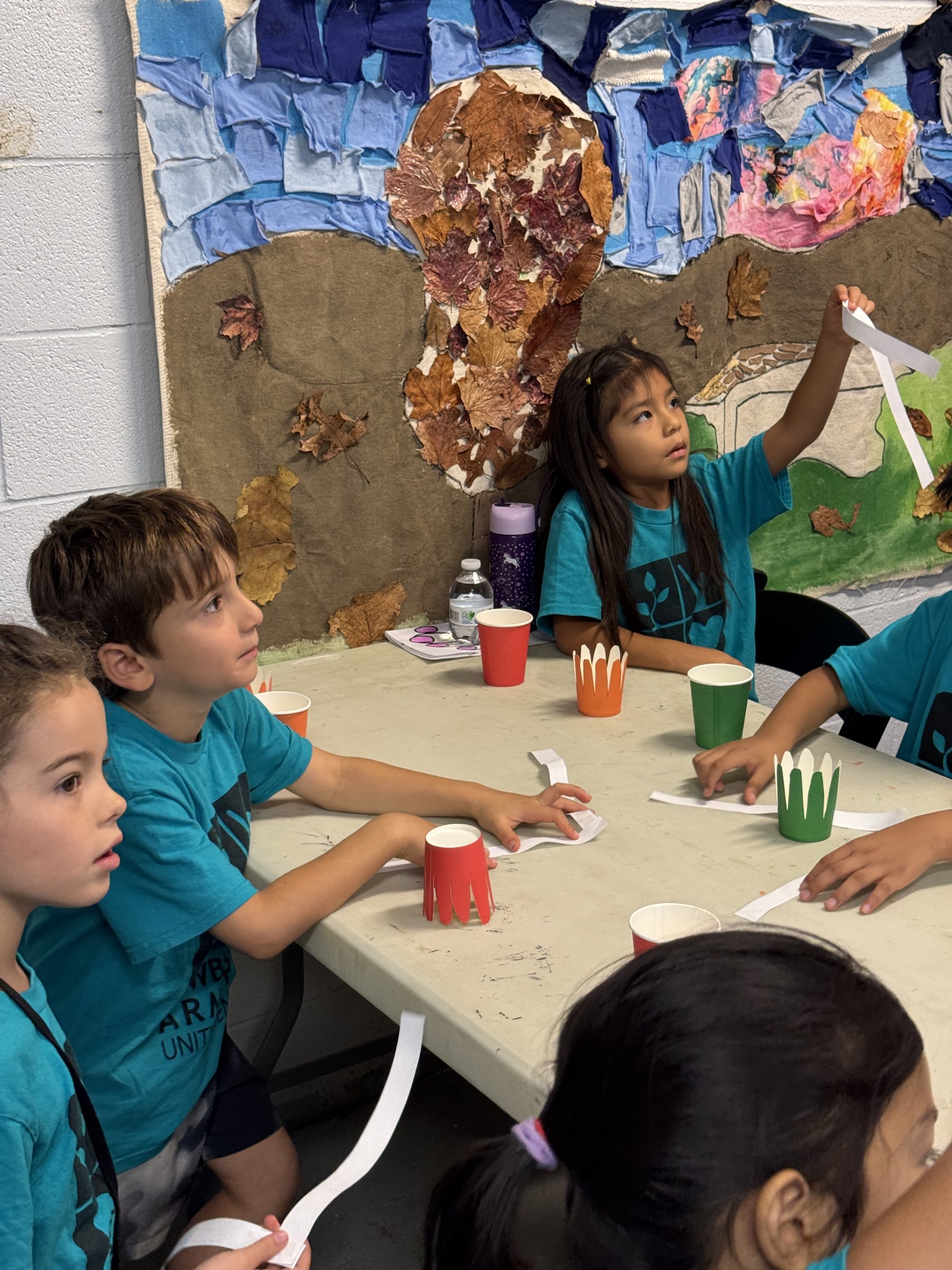 Children assembling colorful paper-cup octopuses